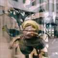 Spiegelung einer Frau im Schaufenster eines Geschäfts in der Fußgängerzone von Kopenhagen.