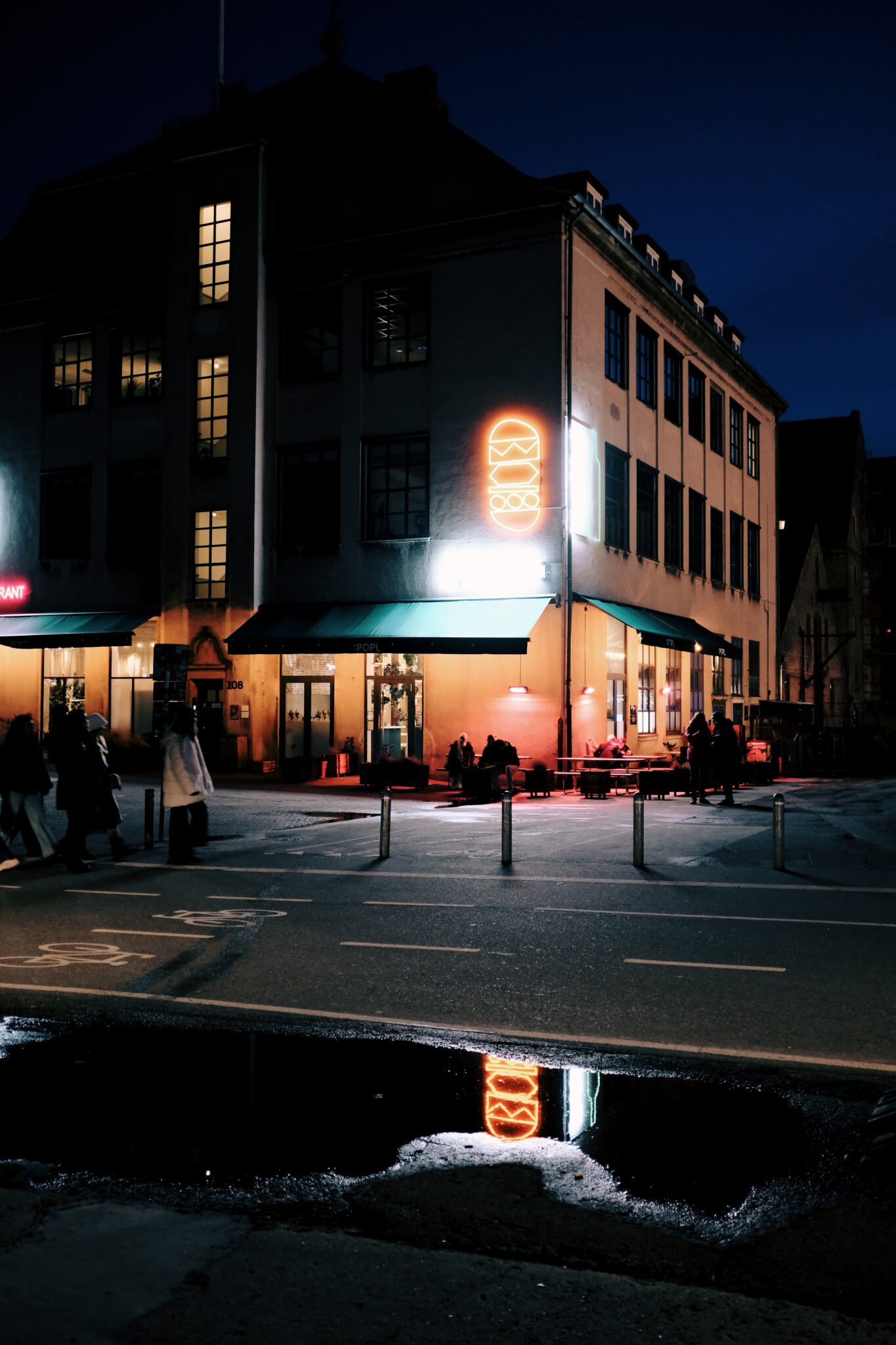 Spiegelungen der Leuchtreklame auf den Straßen von Kopenhagen nach einem Regenschauer.